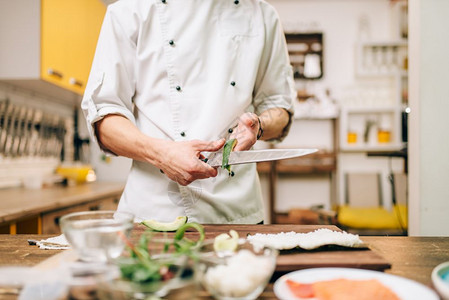 传统的日本烹饪准备过程男烹饪制作寿司卷图片