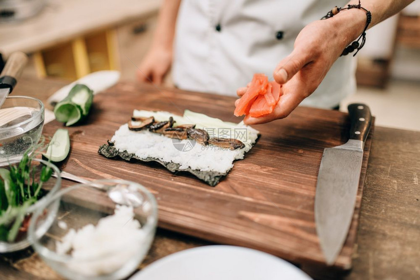 男厨师的手在制作寿司卷图片