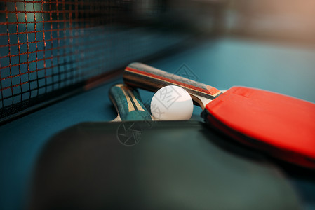 红色乒乓球拍乒乓球拍和乒乓球桌背景