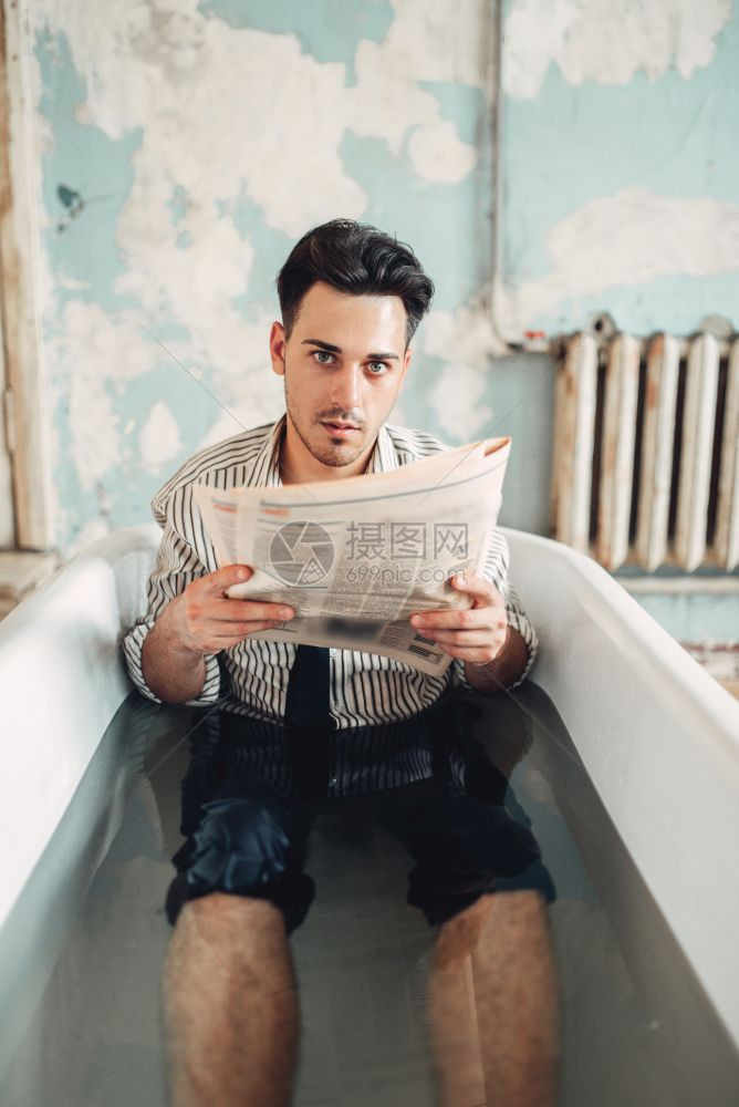 穿着游泳面具的商人坐在浴缸里阅读报纸商业财富概念游泳面具的商人看报纸图片
