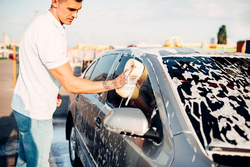 男人在用清洁剂洗车图片
