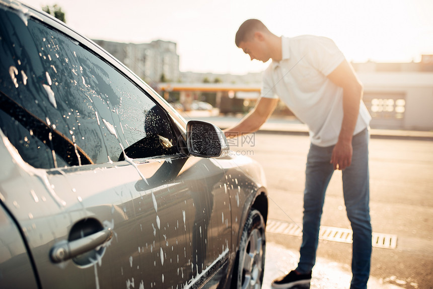 男子在用清洁剂洗车图片
