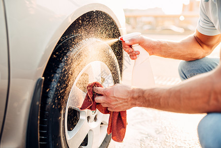 男子清洗汽车轮胎图片