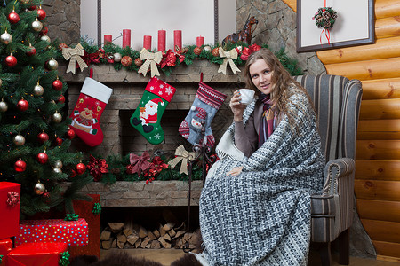 女孩儿坐在圣诞树和壁炉旁边图片