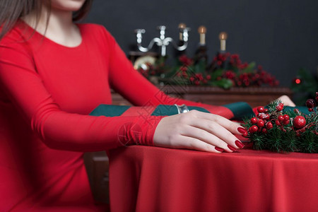 年轻女穿着红色礼服双手紧坐在餐桌旁的女厅里有丰富的内衣图片