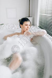 感女人躺在浴中泡沫豪华洗手间用石器装饰放松身体高清图片素材