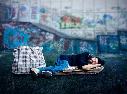 必然性流浪汉睡在街边的纸板上流浪汉睡在外面背景
