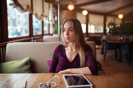 年轻女子坐在咖啡店目视远方图片