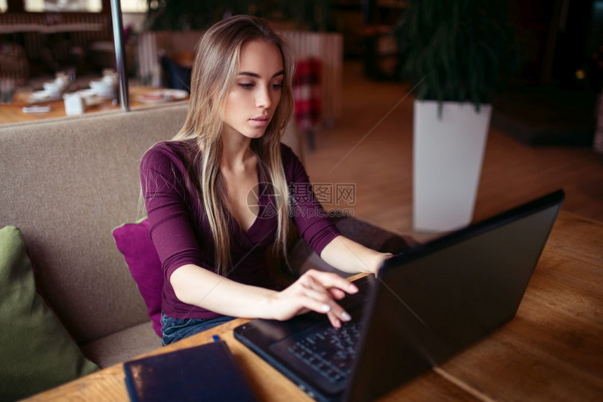 年轻女子在咖啡店使用电脑工作图片