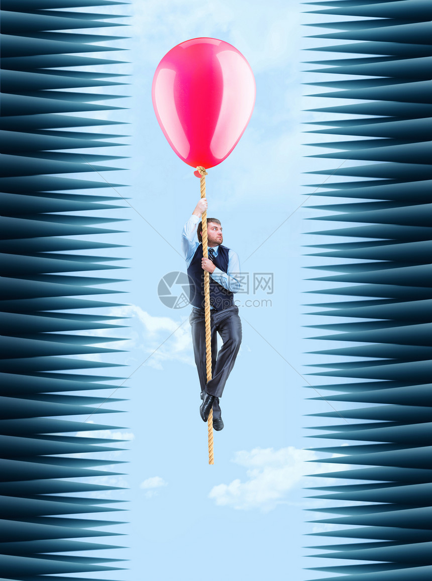 商人挂在绳子上与大球挂在一个棘手的隧道里商人飞行图片