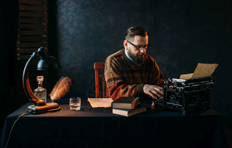 作家坐在古老的打字机前打字图片