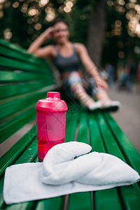 在公园的长椅上运动用瓶子和毛巾图片
