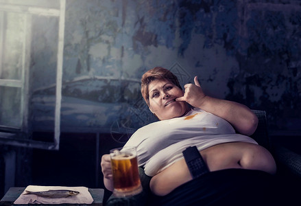 体重超的女人手拿着啤酒肥胖症不健康的生活方式胖女人啤酒背景图片