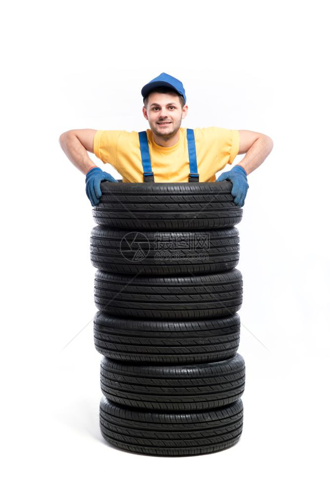 轮胎服务工人站在一堆轮胎里图片
