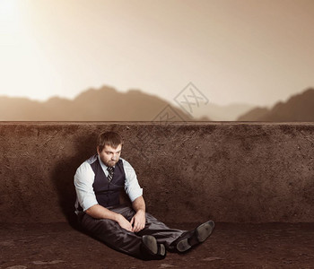坐在沙漠的地板上压抑男人肖像图片