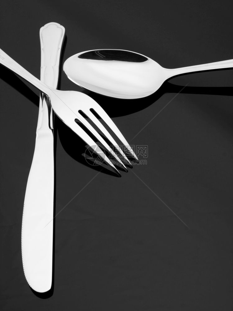 银叉刀和勺子在暗底背景的银叉刀和勺子的侧面叉刀和勺子图片
