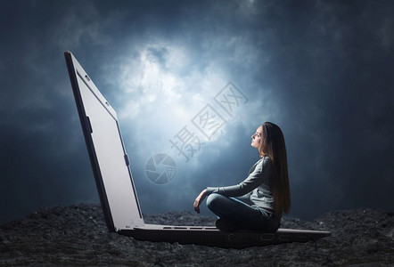 女人坐在大笔记本电脑上看屏幕图片