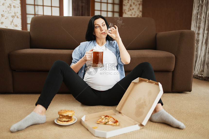 孕妇在起居室休息吃零食图片