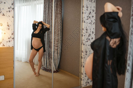 孕妇在卧室镜子里看着自己图片