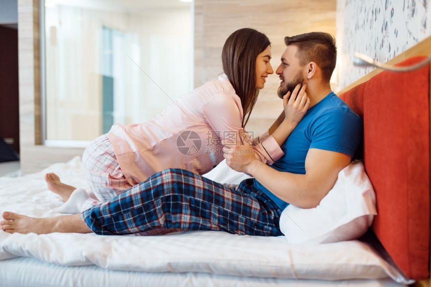 快乐的情侣在床上拥吻图片