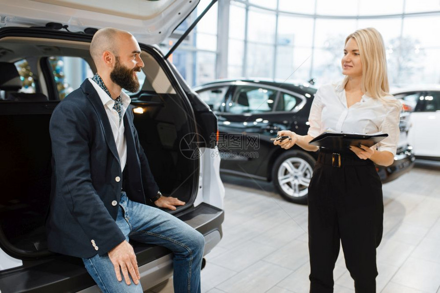 美女销售正在向男顾客介绍新汽车图片