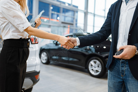 顾客和售货员在汽车经销店里握手图片