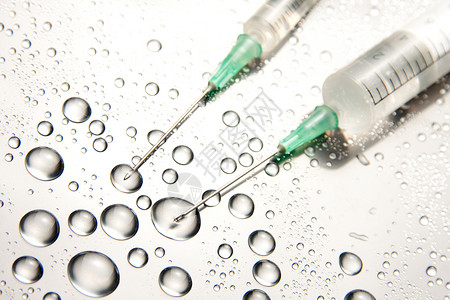 两个医疗注射器和水滴背景图片