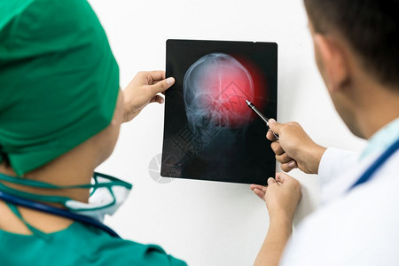 医生检查病人x光薄膜脑头骨图片