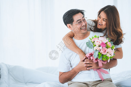 老年夫妻手捧花看着对方幸福的笑起来图片