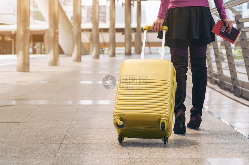 携带旅行袋或李在机场终点站行走前往国外旅的妇女者图片