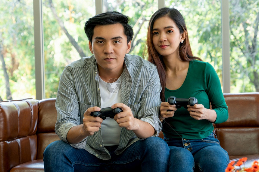 青年快乐夫妇在客厅玩电子游戏图片