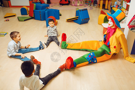孩子们与小丑一起快乐的玩耍高清图片