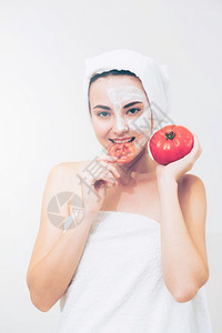 敷着面膜手拿番茄的女子背景图片