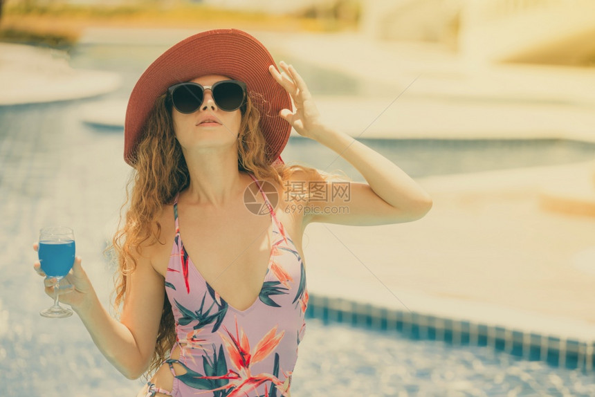 穿着泳衣的快乐年轻女子在豪华度假村游泳池玩得很开心图片