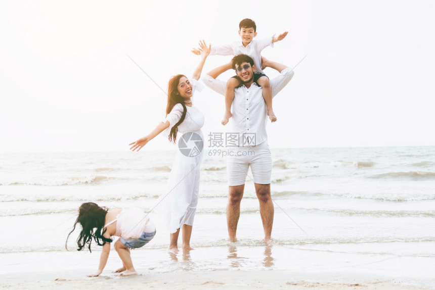热带沙滩上度假的幸福一家人图片