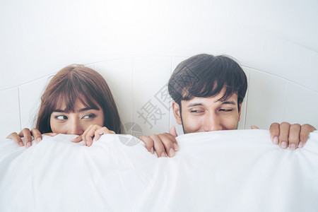 快乐的年轻夫妇在早晨醒来后家庭卧室放松背景图片