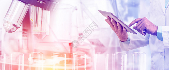 不育的科学研究和技术概念科学家持有平板电脑带实验室背景的科学仪器显微镜和化学试验管设计图片