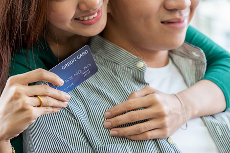 个人信用卡使用记录表年轻夫妇使用信卡在家中的互联网站上在线购物信用卡号码是假冒的信用卡上没有个人信息网上商业购物概念背景