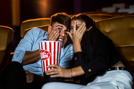 一对情侣在电影院看恐怖片感到害怕图片