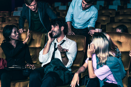 电影观众在电影院讲手机的讨厌男人电影院里的很生气背景