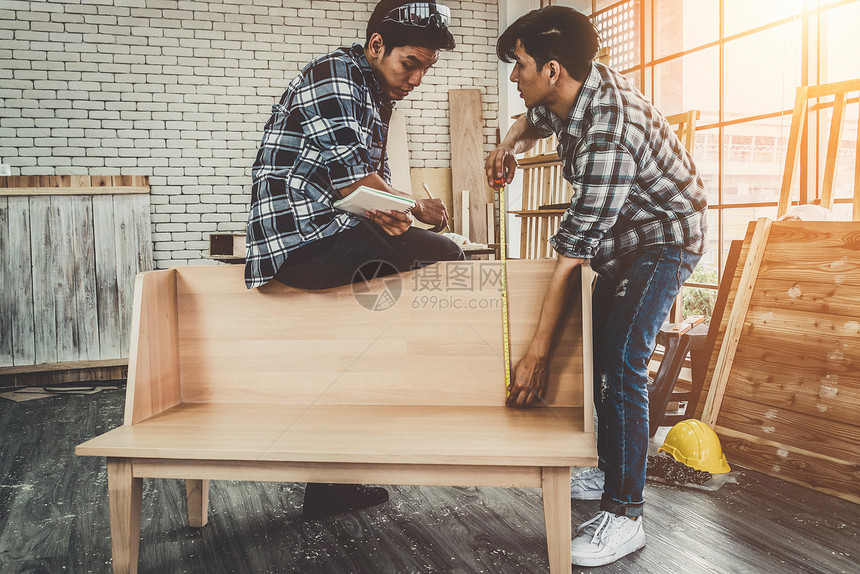 在生产建筑材料或木制家具的讲习班上从事木制工艺的的年轻图片