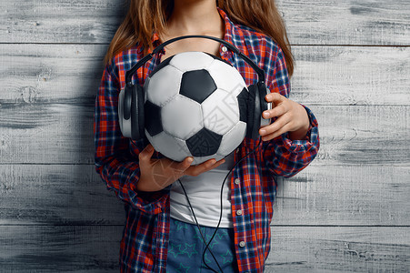 小女孩抱着戴耳机的足球图片