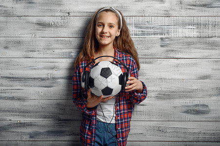 小女孩抱着戴耳机的足球图片