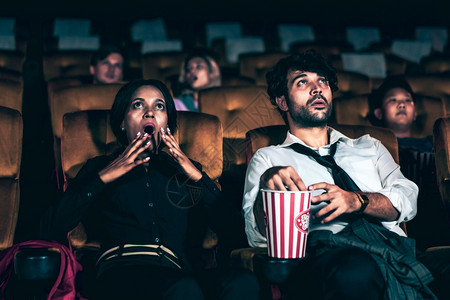 坐在电影院里的观众看着可怕的恐怖图片