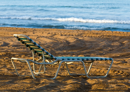 海边沙滩上的旧塑料遮晒机背景图片