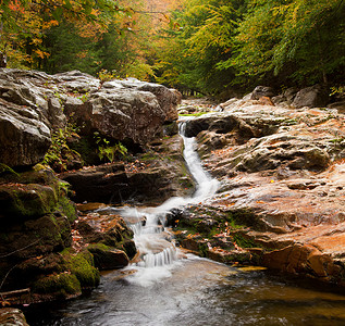 秋天在巨石和岩上流水的长图象图片