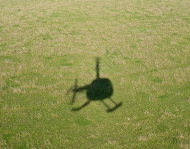 绿色草原下的直升机阴影图片