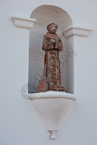 古老的瓷砖和石膏圣徒带着一把吉他仰雕像的腿图片