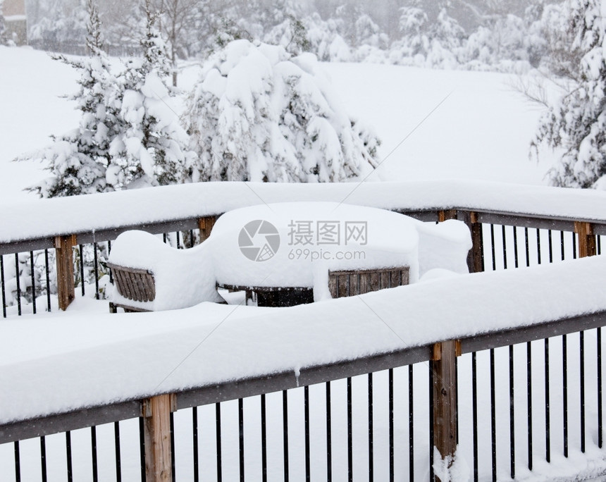 埋雪中的木板桌和椅子图片