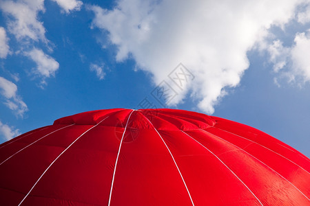 红色的热气球顶与云彩的蓝色天空相对图片